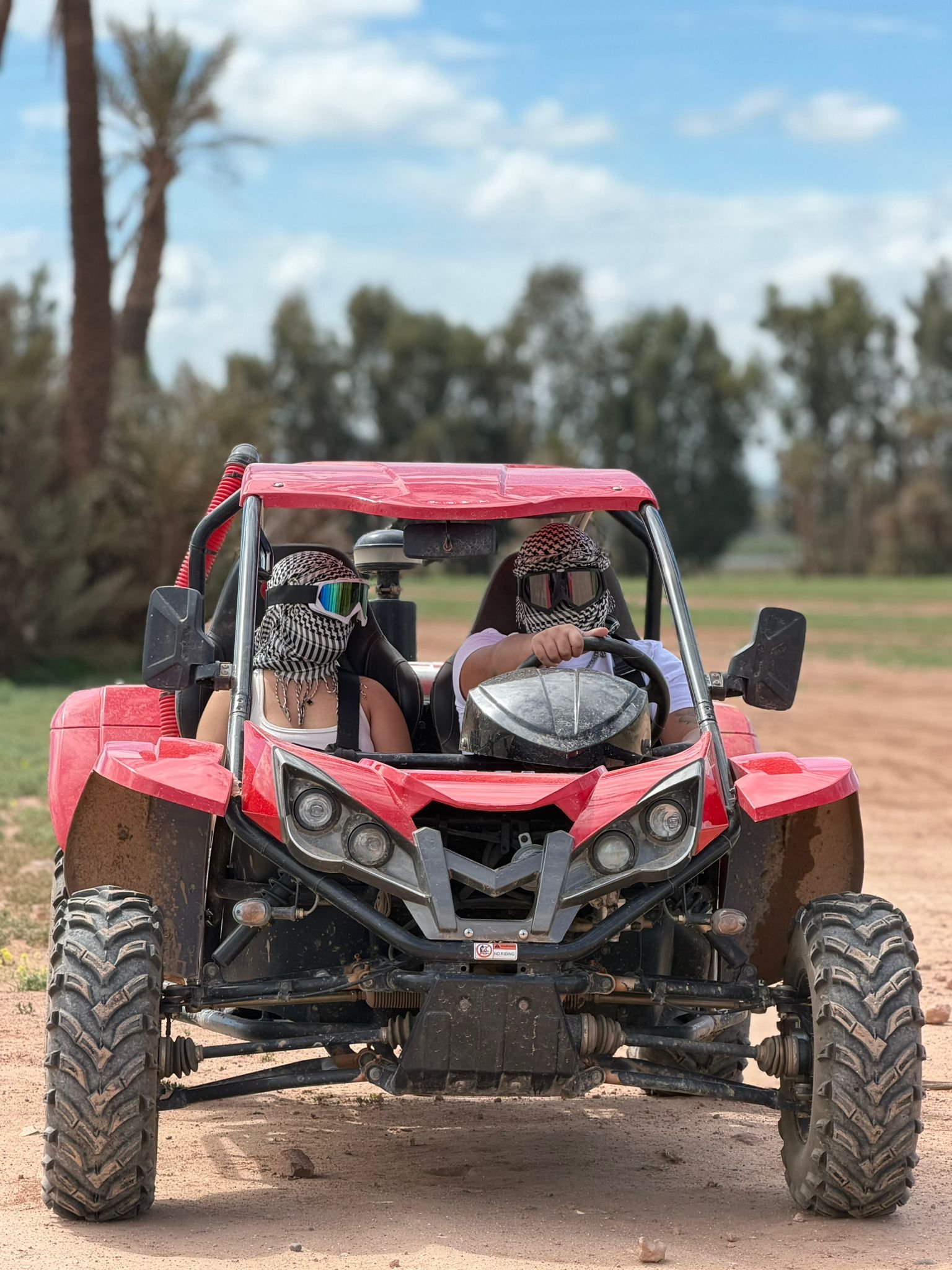 Buggy rojo con dos pilotos en una pista del desierto de Marrakech